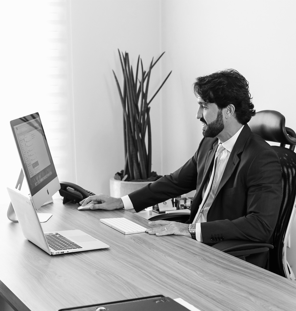 Homem sorrindo ao trabalhar em seu IMac.